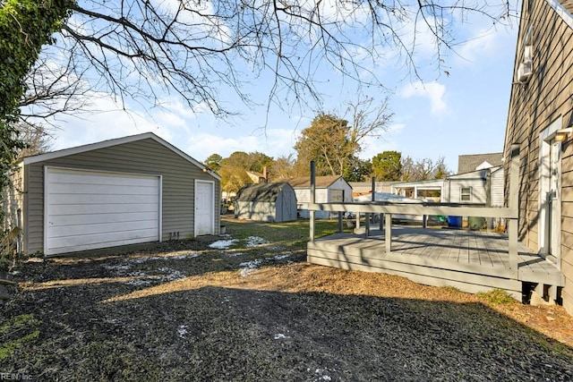 view of yard featuring a storage unit, a garage, and a wooden deck