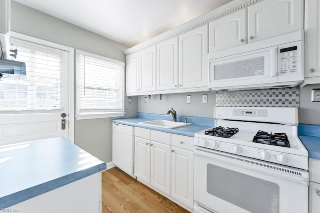 kitchen featuring white appliances, white cabinetry, light hardwood / wood-style flooring, and sink