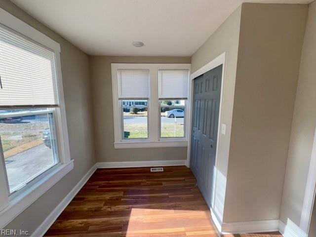 hall with plenty of natural light and dark hardwood / wood-style floors