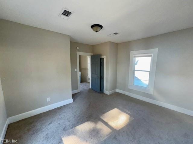 unfurnished bedroom with dark colored carpet