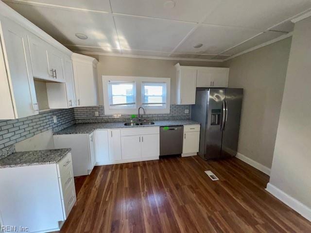 kitchen featuring decorative backsplash, sink, white cabinets, and stainless steel appliances