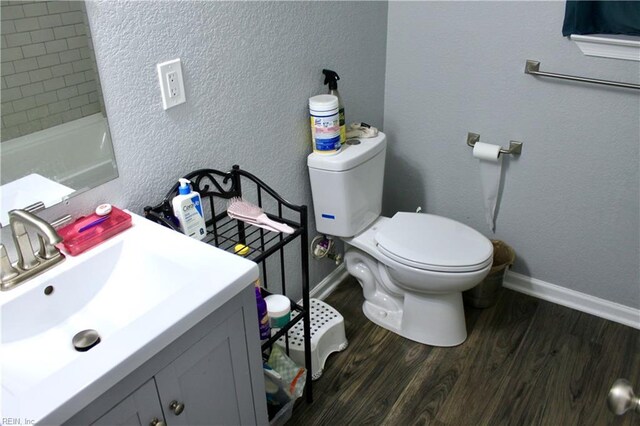 bathroom featuring toilet, vanity, and hardwood / wood-style floors