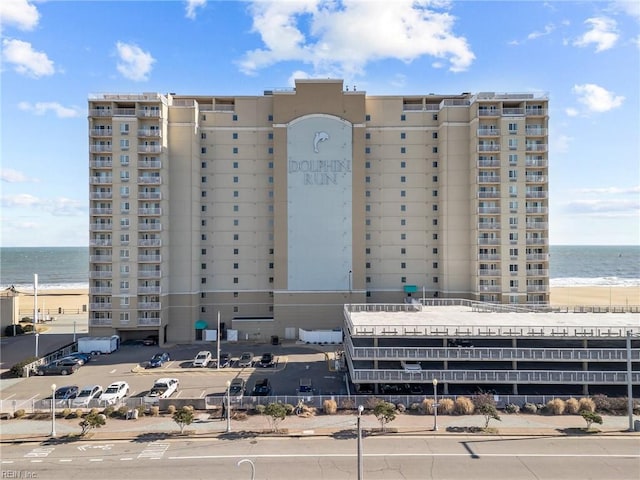 view of building exterior featuring a beach view and a water view