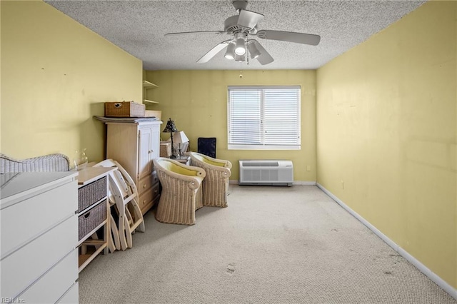 sitting room featuring an AC wall unit, a textured ceiling, ceiling fan, and light colored carpet