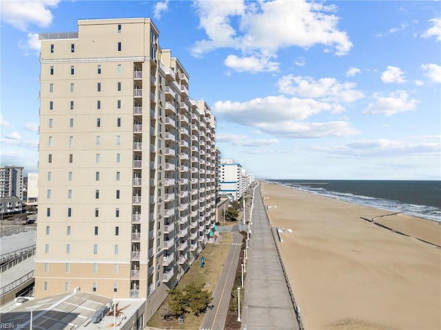 view of building exterior featuring a beach view and a water view