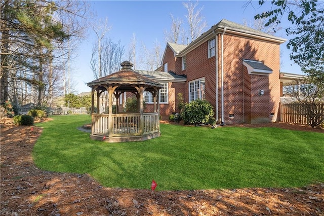 rear view of property featuring a gazebo, a yard, and a wooden deck