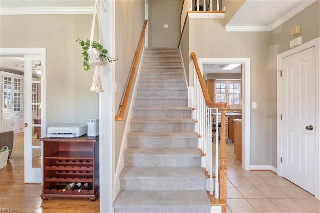 stairway with tile patterned flooring and crown molding