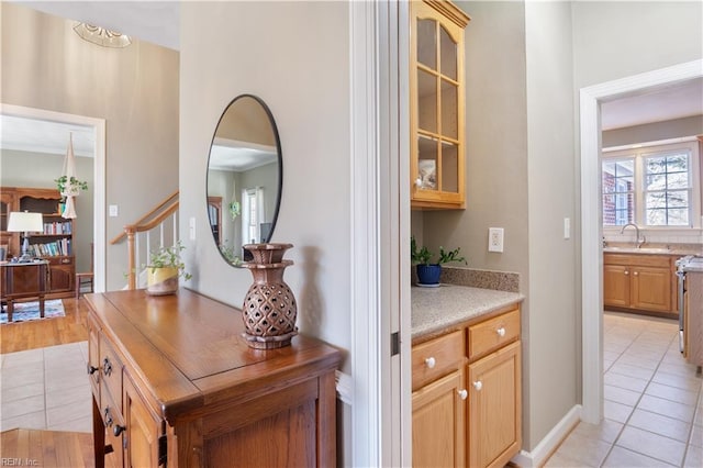 bar with sink, light brown cabinets, and light tile patterned floors