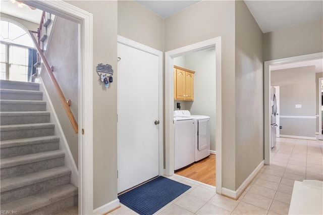 washroom with light tile patterned floors, cabinets, and independent washer and dryer