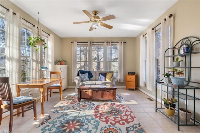 living area featuring ceiling fan, a healthy amount of sunlight, and light tile patterned floors