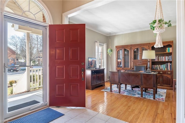 foyer featuring ornamental molding and light hardwood / wood-style flooring