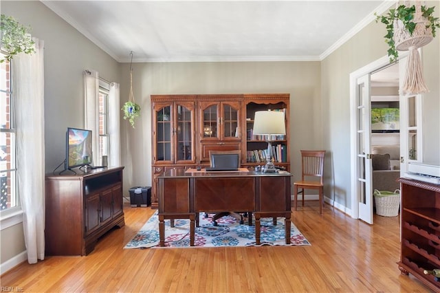 office featuring a wealth of natural light, crown molding, and light hardwood / wood-style flooring