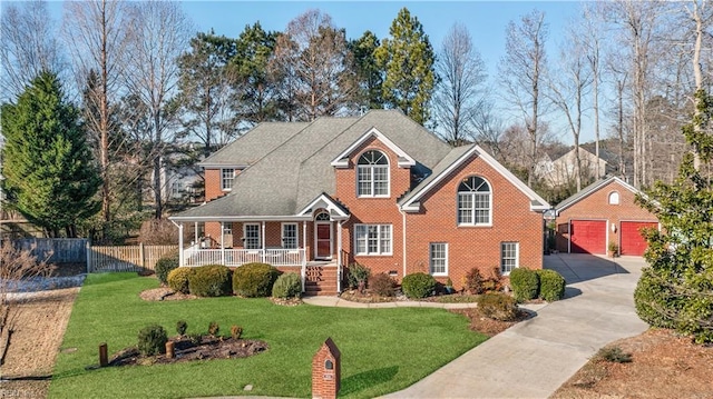 view of front property with a garage, a porch, an outdoor structure, and a front lawn