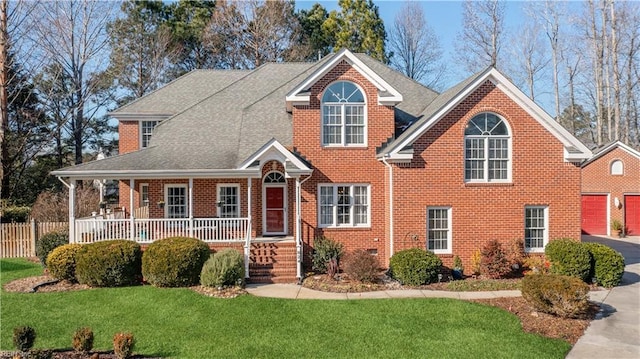 front facade with covered porch, a front lawn, and a garage