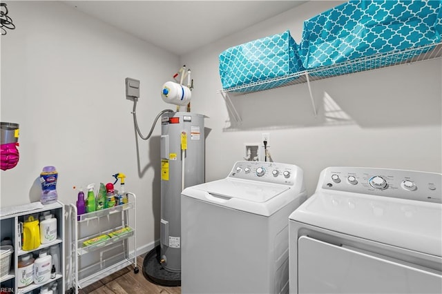 clothes washing area with water heater, washing machine and dryer, and hardwood / wood-style floors