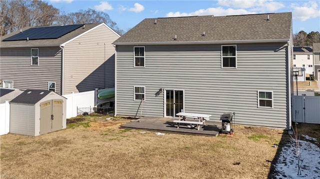 rear view of property with a yard, a storage unit, and a patio area