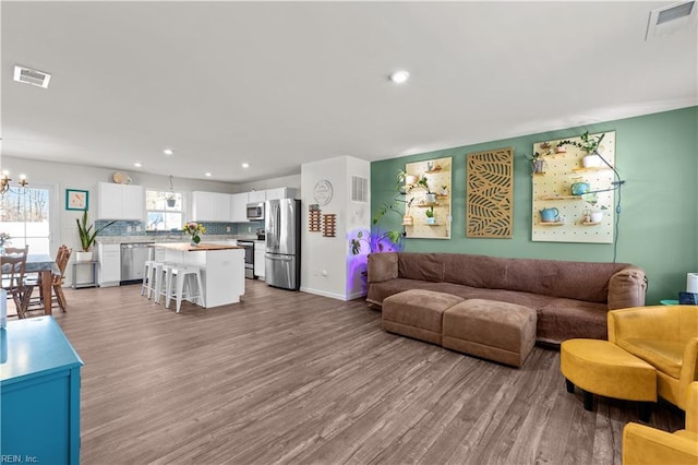 living room with light hardwood / wood-style flooring and a chandelier