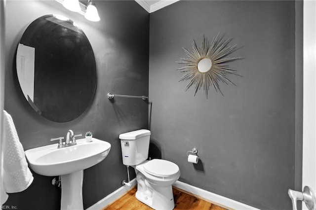 bathroom featuring toilet, crown molding, hardwood / wood-style floors, and sink