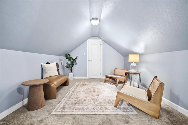 sitting room with carpet, vaulted ceiling, and a textured ceiling