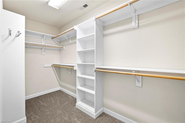 spacious closet featuring dark colored carpet