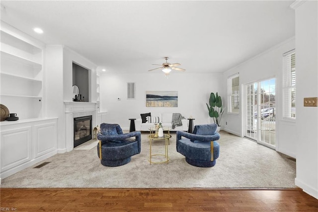 carpeted living room featuring ceiling fan and built in features