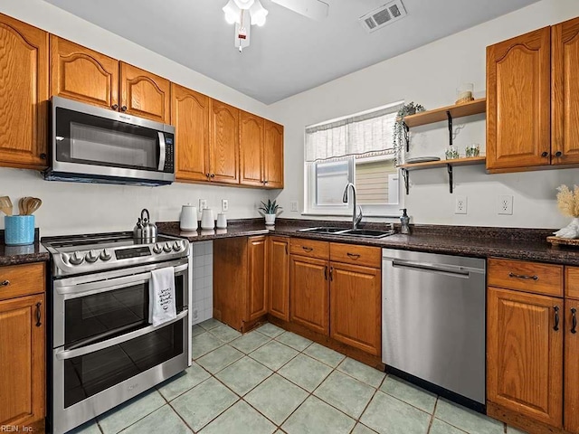 kitchen featuring ceiling fan, sink, appliances with stainless steel finishes, and light tile patterned floors