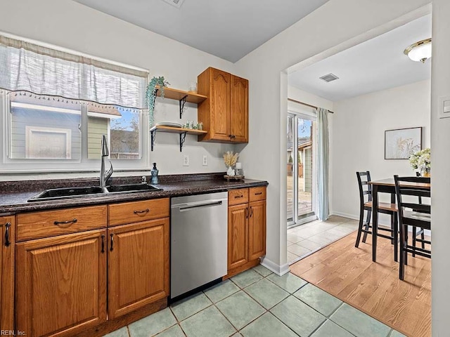 kitchen featuring sink, stainless steel dishwasher, and light tile patterned flooring