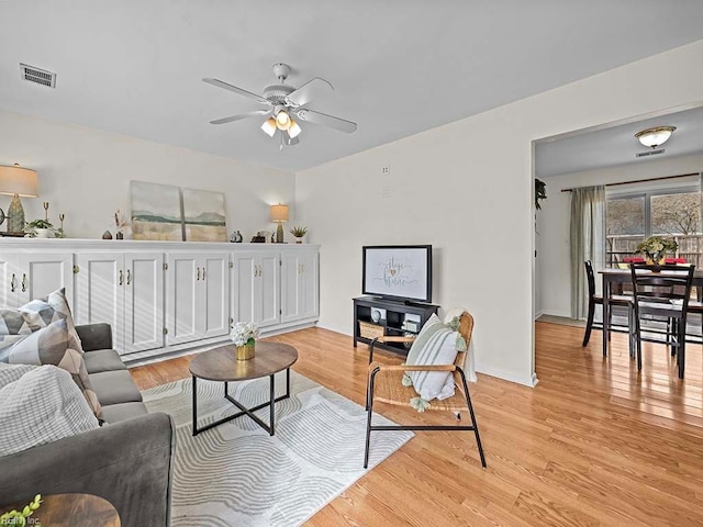 living room with ceiling fan and light hardwood / wood-style floors