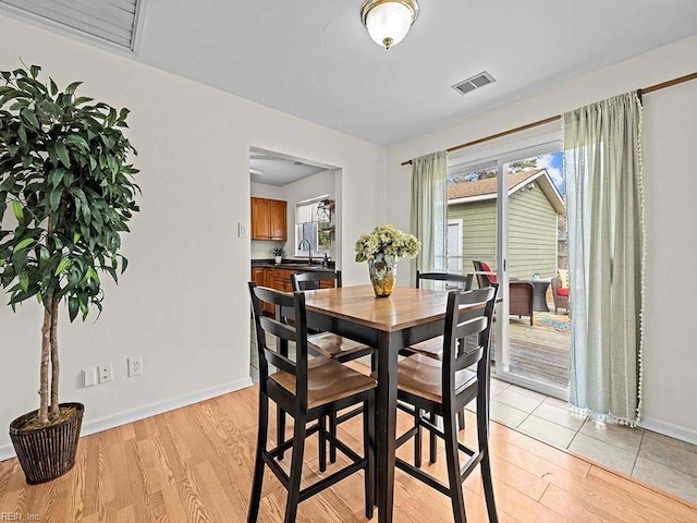 dining room featuring sink and light hardwood / wood-style floors