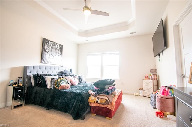 bedroom featuring ceiling fan, carpet flooring, and a tray ceiling