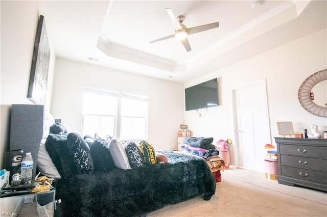 bedroom featuring ceiling fan, carpet, and a tray ceiling