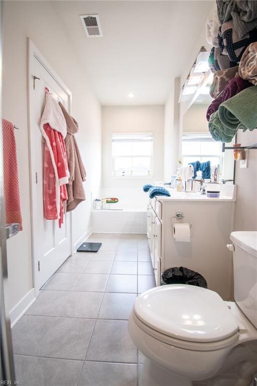 bathroom with vanity, plenty of natural light, tile patterned floors, and toilet