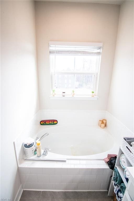 bathroom with tile patterned floors and tiled tub