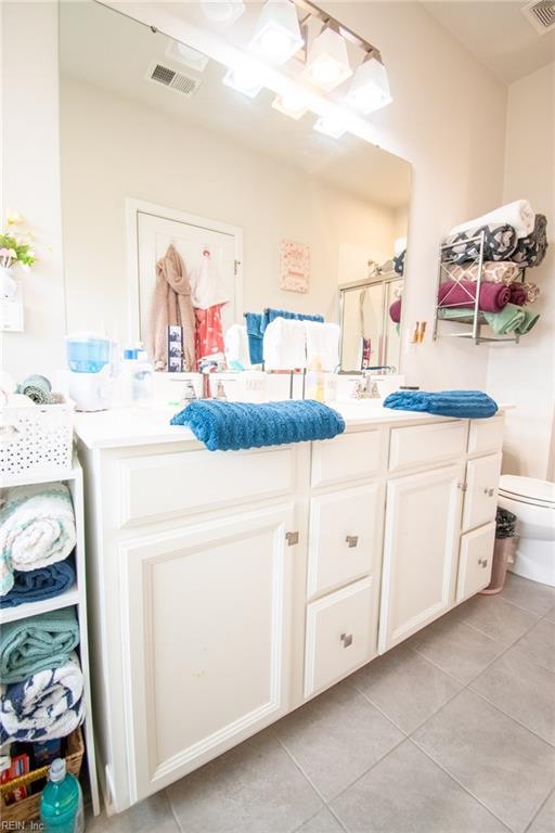 bathroom featuring tile patterned flooring, an enclosed shower, vanity, and toilet