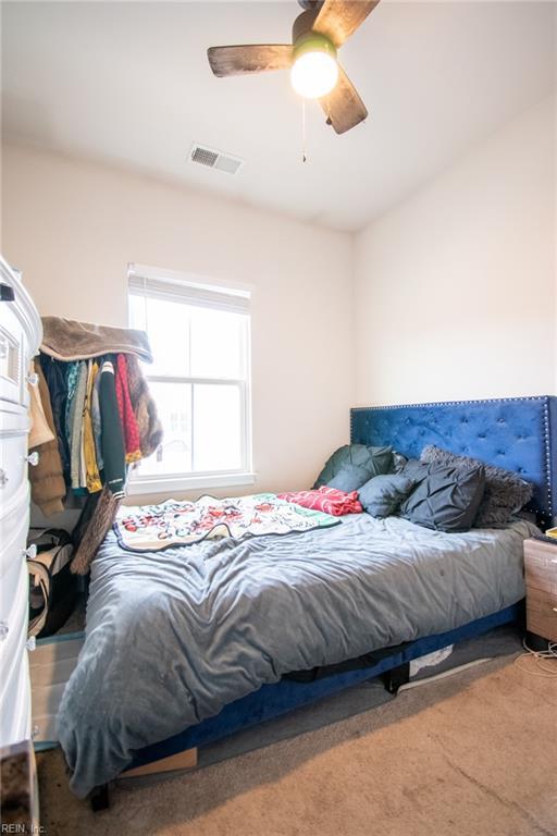 bedroom featuring ceiling fan and carpet