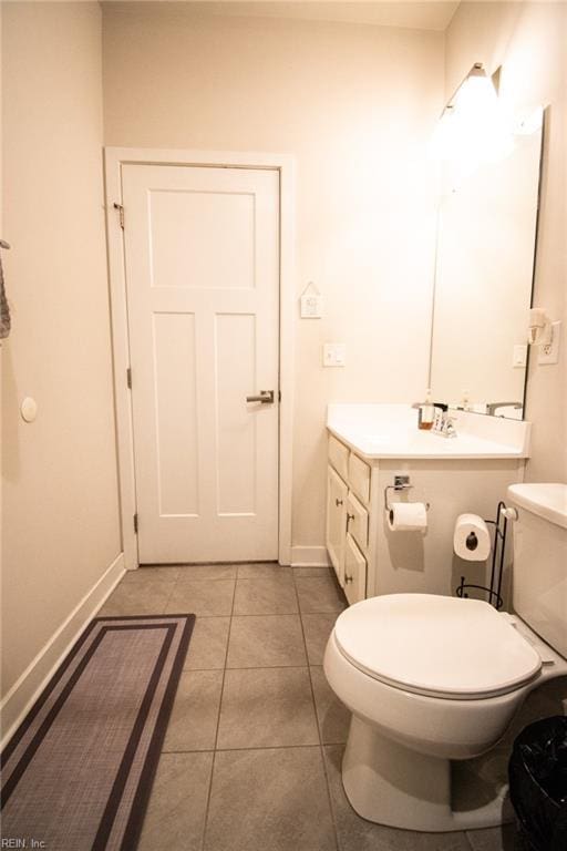 bathroom with toilet, vanity, and tile patterned floors