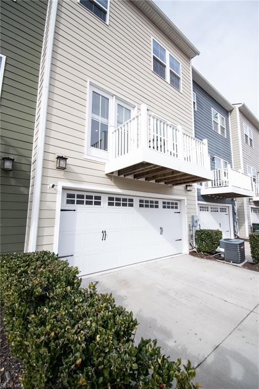 exterior space featuring a balcony, central air condition unit, and a garage