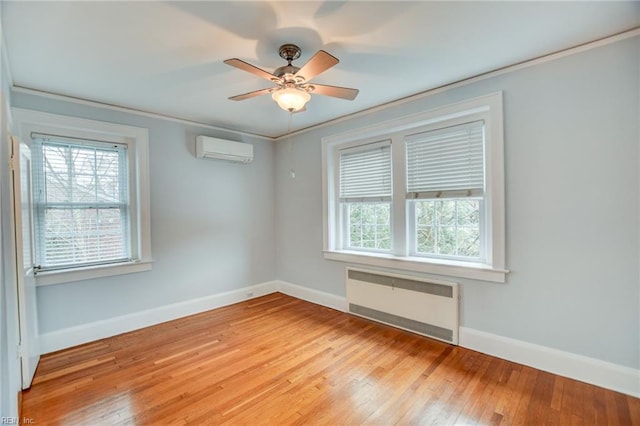 unfurnished room with an AC wall unit, radiator heating unit, light wood-type flooring, ceiling fan, and crown molding