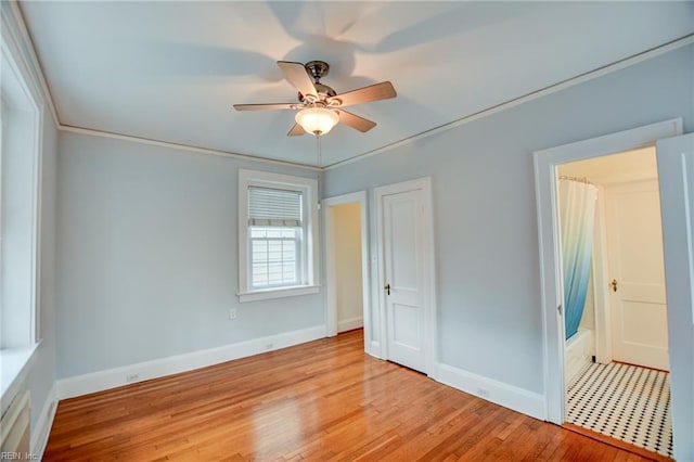 unfurnished bedroom featuring ceiling fan, light hardwood / wood-style floors, and crown molding