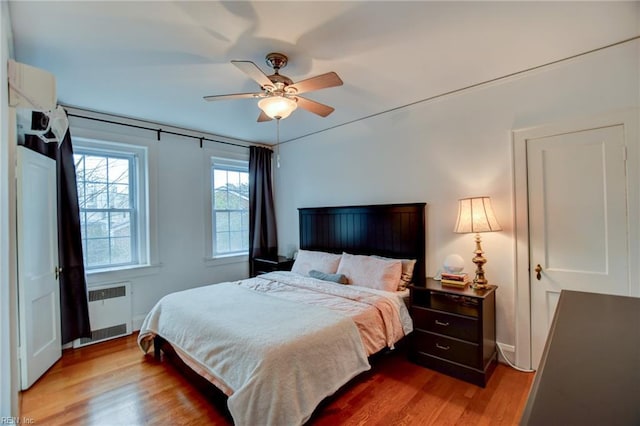 bedroom featuring radiator, ceiling fan, and wood-type flooring