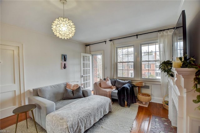 living room featuring wood-type flooring, a chandelier, and ornamental molding