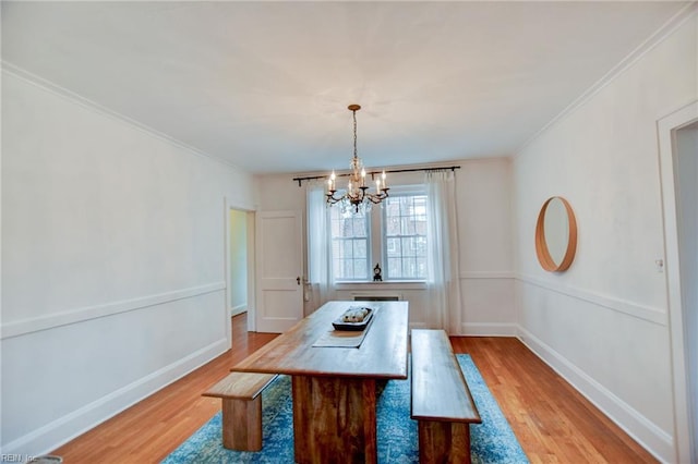 dining room featuring an inviting chandelier, crown molding, and light hardwood / wood-style flooring