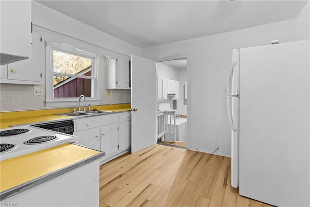 kitchen with decorative backsplash, sink, white fridge, and white cabinetry