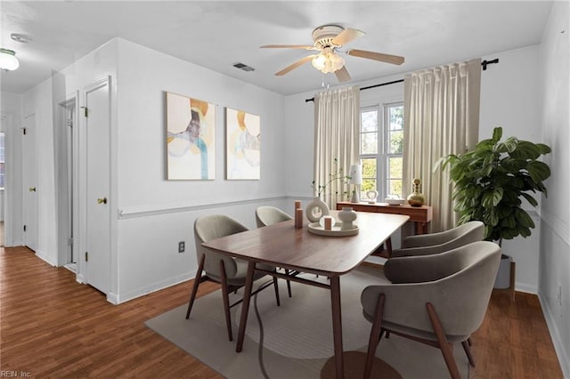 dining space with ceiling fan and dark wood-type flooring