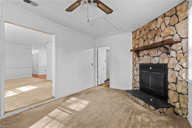 unfurnished living room featuring ceiling fan, light colored carpet, a fireplace, and crown molding