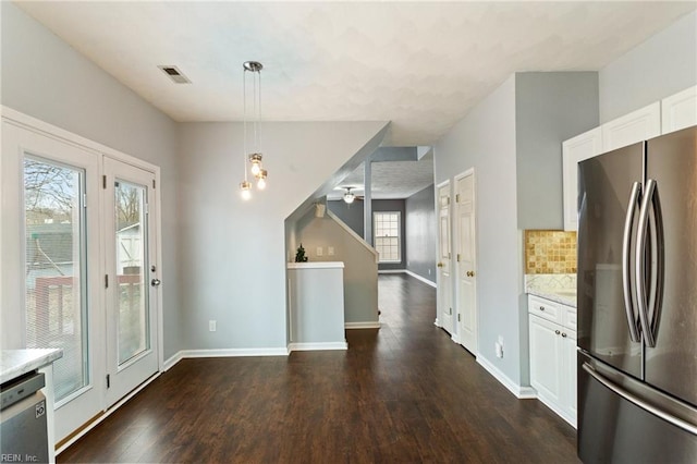 kitchen with hanging light fixtures, tasteful backsplash, stainless steel appliances, and white cabinetry