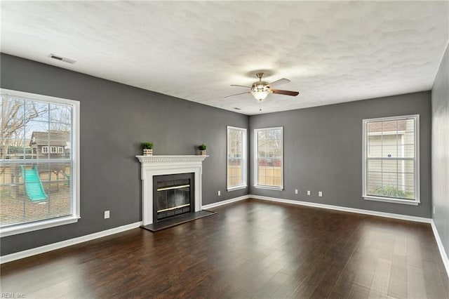 unfurnished living room featuring ceiling fan and dark wood-type flooring