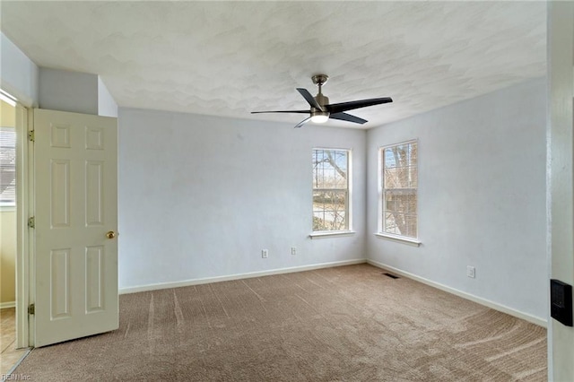 carpeted spare room featuring ceiling fan