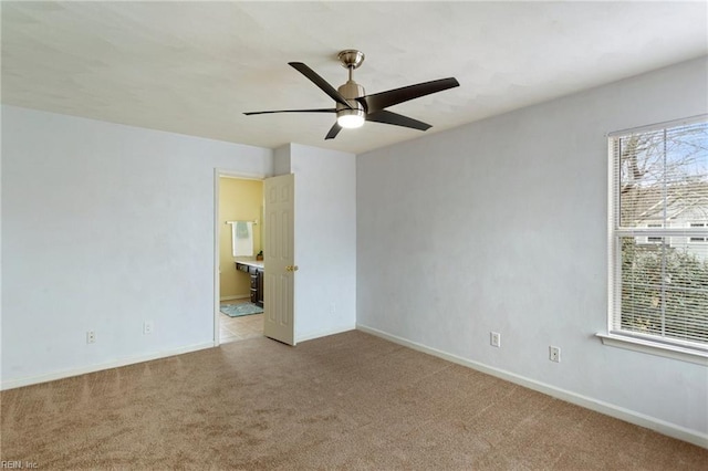 carpeted spare room featuring ceiling fan