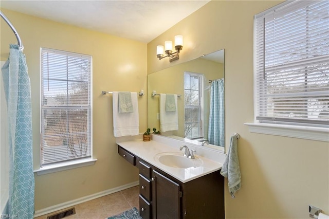 bathroom featuring a wealth of natural light, tile patterned floors, and vanity